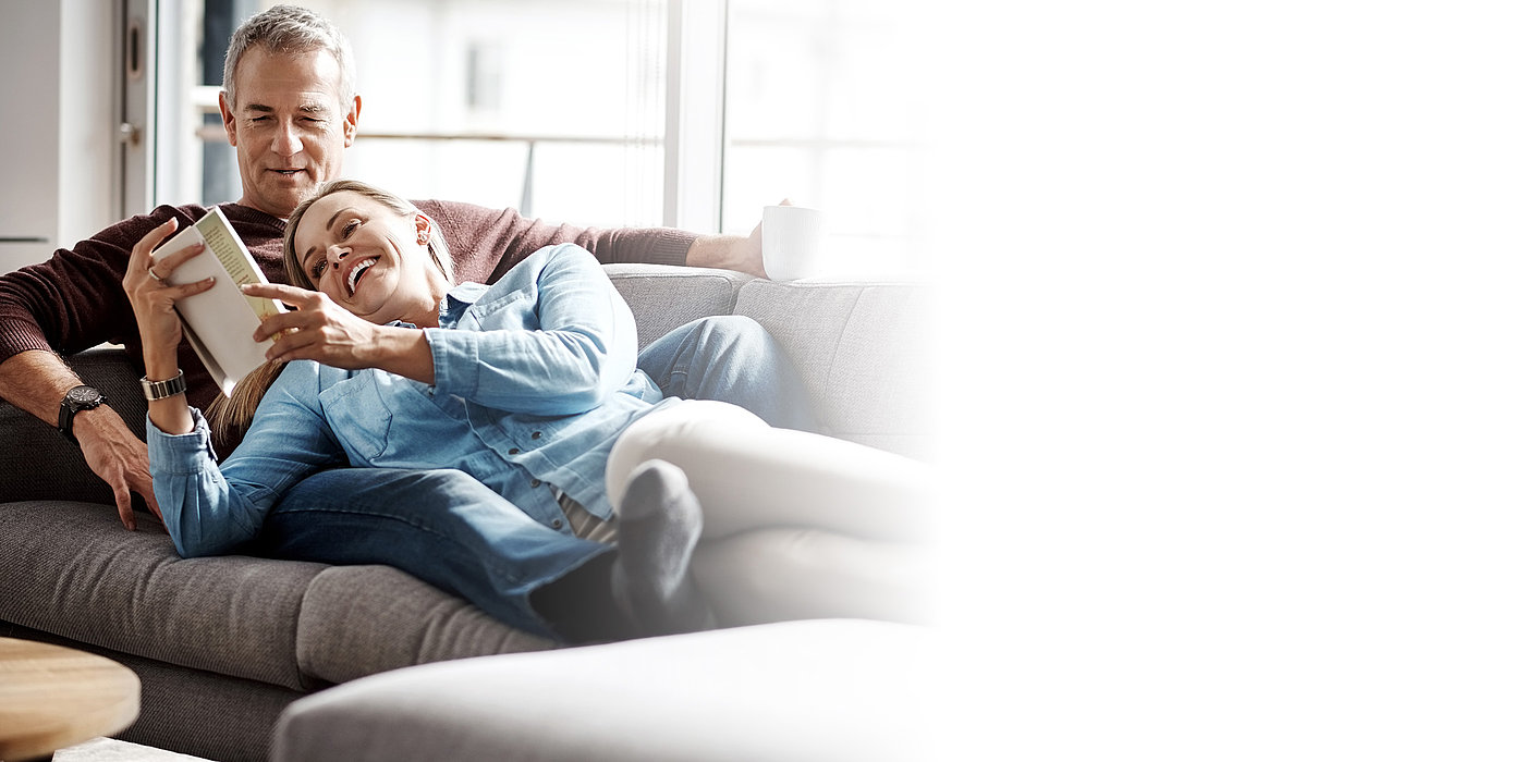 Ein Paar macht es sich gemütlich auf der Couch.
